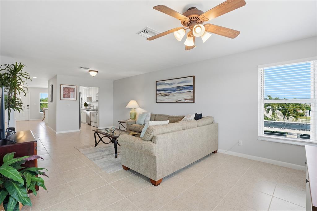 A living room with a beige sectional sofa, tile flooring, and a ceiling fan — 912 SE 46TH STREET UNIT 201, CAPE CORAL, FL
