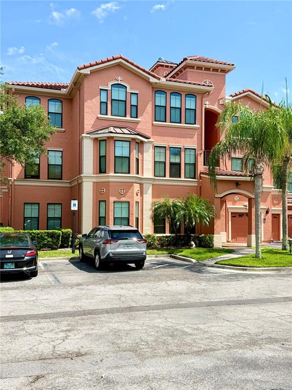 A multi-story peach-colored apartment building with a parking lot in the foreground — 2747 VIA CAPRI UNIT 1126, CLEARWATER, FL
