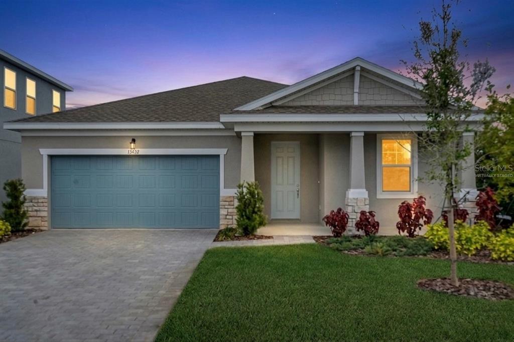 A single-story house with a blue garage door, stone accents, and a covered front porch — 13470 TURNLEAF BOULEVARD, PUNTA GORDA, FL