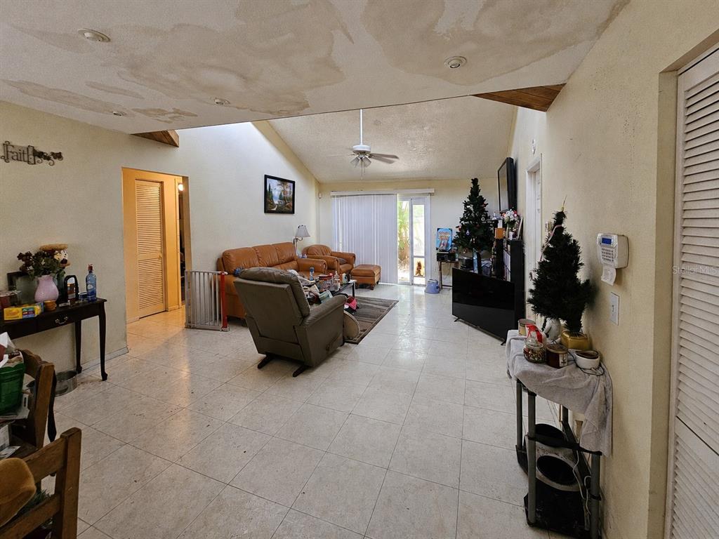 A living room with tile floors, a vaulted ceiling, and a large sliding glass door — 4153 LANCASTER DRIVE, SARASOTA, FL