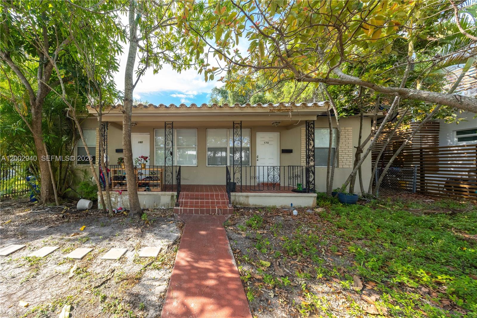 A single-story duplex with a covered front porch, tiled steps, and a red walkway — 170 NE 48th St, Miami FL 33137, MIAMI, FL