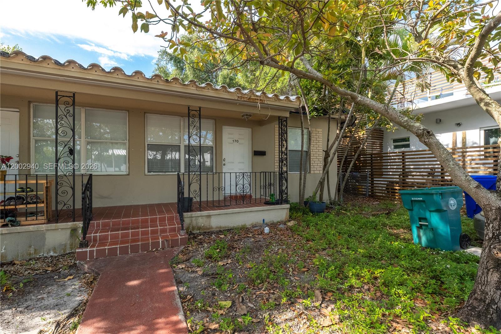 The exterior of a single-story house features a tiled porch with decorative wrought iron railings — 170 NE 48th St, Miami FL 33137, MIAMI, FL