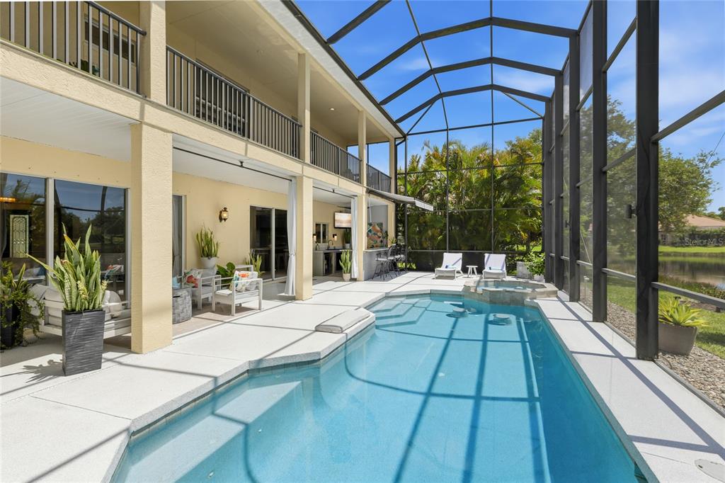 A screened-in pool patio features a swimming pool, hot tub, and covered seating area — 6971 SCRUB JAY DRIVE, SARASOTA, FL