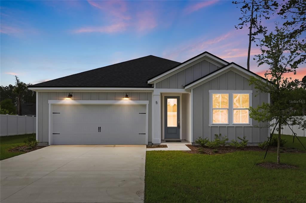 A single-story house with gray vertical siding, a two-car garage, and a concrete driveway — 5 REINE PLACE, PALM COAST, FL