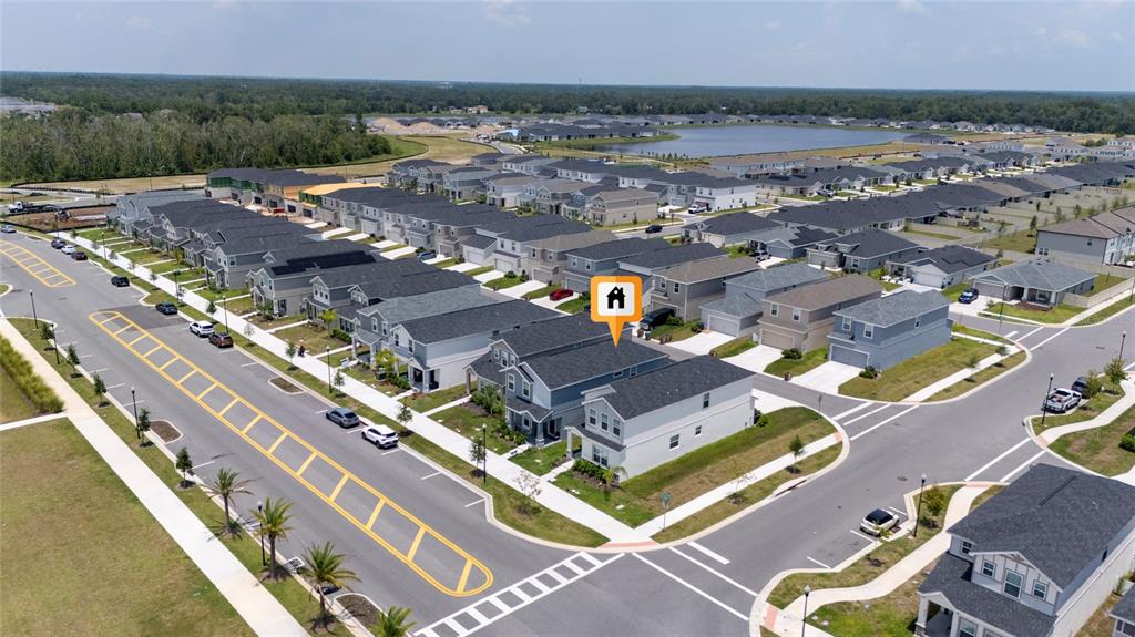 An aerial view shows a residential neighborhood with a community pool and townhomes — 445 SILVERBELL TRAIL, ST CLOUD, FL