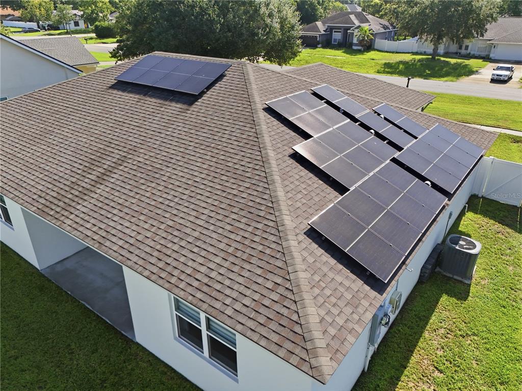 An aerial view shows a residential roof with two separate solar panel arrays installed — 2228 BANCROFT BOULEVARD, ORLANDO, FL