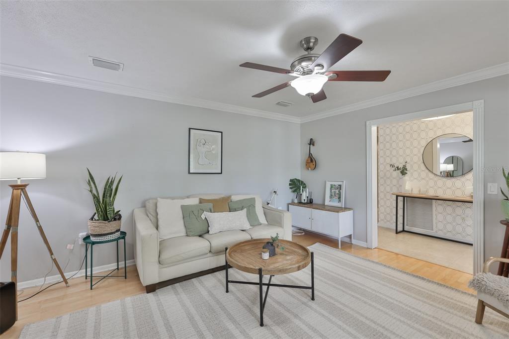 A living room features a light-colored sofa, a round wooden coffee table, and a ceiling fan — 1311 ESTATEWOOD DRIVE, BRANDON, FL