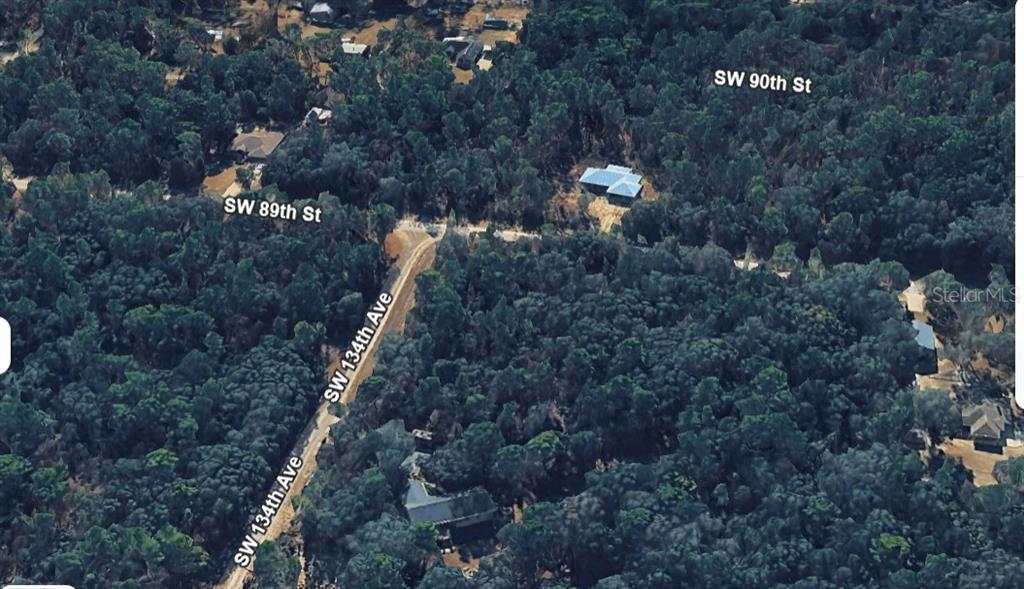 This aerial view shows a house nestled within a dense forest near a road intersection — SW 88 STREET, DUNNELLON, FL