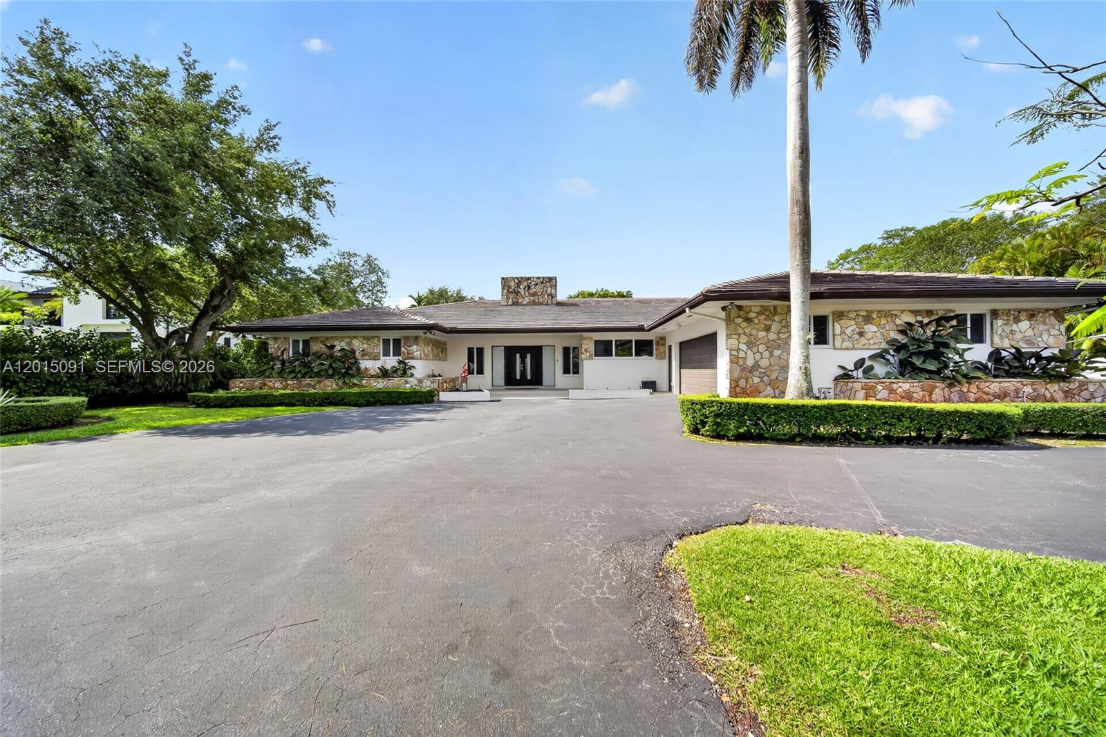 A single-story house with a stone facade, a large driveway, and a palm tree — 6650 SW 112th St, Pinecrest FL 33156, PINECREST, FL