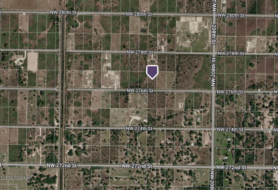 This is an aerial map showing a land parcel marked with a purple pin — 21117 NW 276TH STREET, OKEECHOBEE, FL