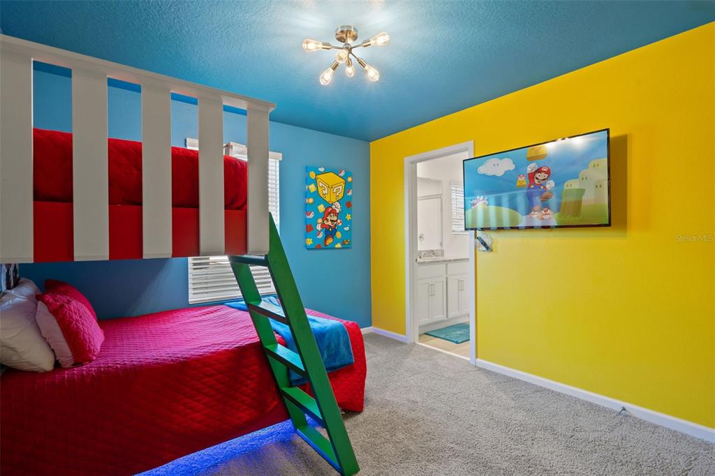 A bedroom features a Mario-themed bunk bed, yellow and blue walls, and a wall-mounted television — 2358 ZABALLINA PLACE, KISSIMMEE, FL