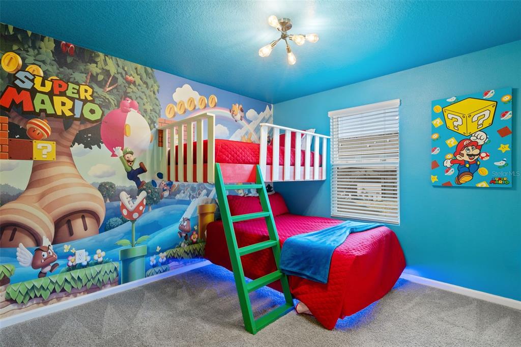 A bedroom features a Super Mario-themed mural, a bunk bed with a green ladder, and carpeting — 2358 ZABALLINA PLACE, KISSIMMEE, FL