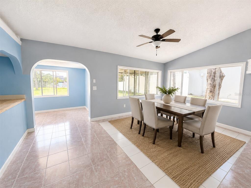 A dining room with a wooden table, six chairs, a rug, and light blue walls — 4824 LIMESTONE DRIVE, PORT RICHEY, FL