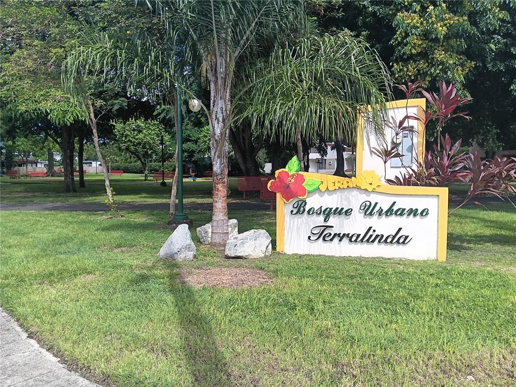 A sign reading Bosque Urbano Terralinda stands in a grassy park with trees and benches — URB. TERALINDA CALLE TOLEDO UNIT #6, CAGUAS, PR