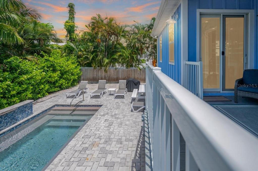 A blue house exterior features a small swimming pool, lounge chairs, and a white railing — 308 57TH STREET UNIT A & B, BRADENTON BEACH, FL