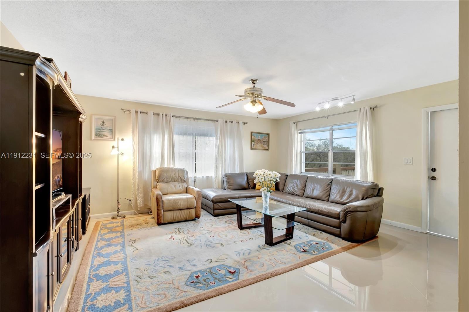 A living room features a brown sectional sofa, a recliner, and a large area rug — 1943 Monroe St # 310D, Hollywood FL 33020, HOLLYWOOD, FL