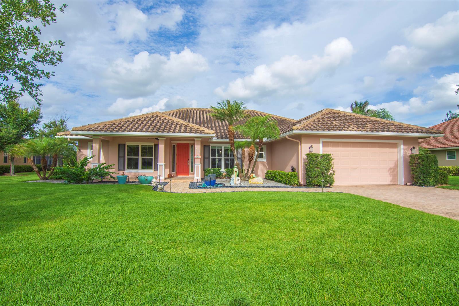 A single-story house with a tiled roof, a red front door, and a green lawn — 470 Pittman Avenue, Vero Beach FL 32968, VERO BEACH, FL