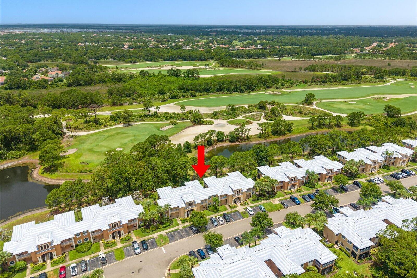 An aerial view shows a multi-unit residential building with a red arrow pointing toward it — 8340 Mulligan Circle # 2024, FL 34986, FL