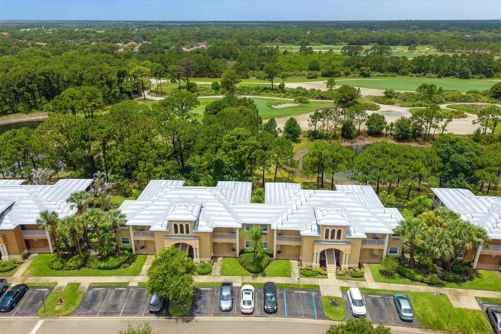 An aerial view of a multi-story apartment building with a metal roof near a golf course — 8340 Mulligan Circle # 2024, FL 34986, FL