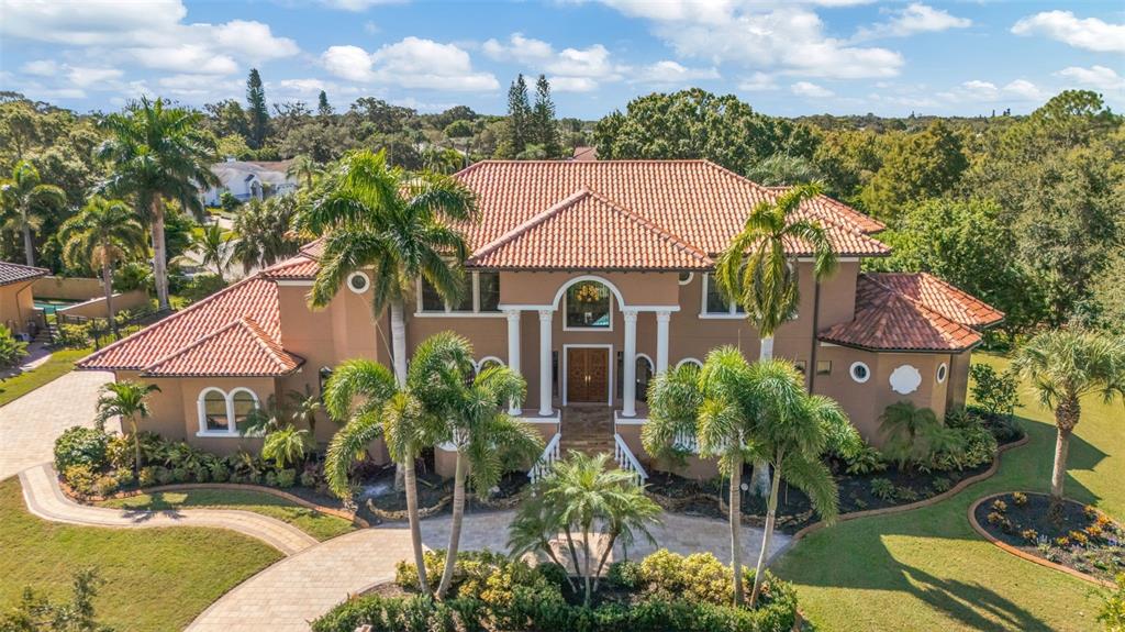 An aerial view of a two-story stucco house with a red tile roof and palms — 1079 ASHLAND AVENUE, TARPON SPRINGS, FL