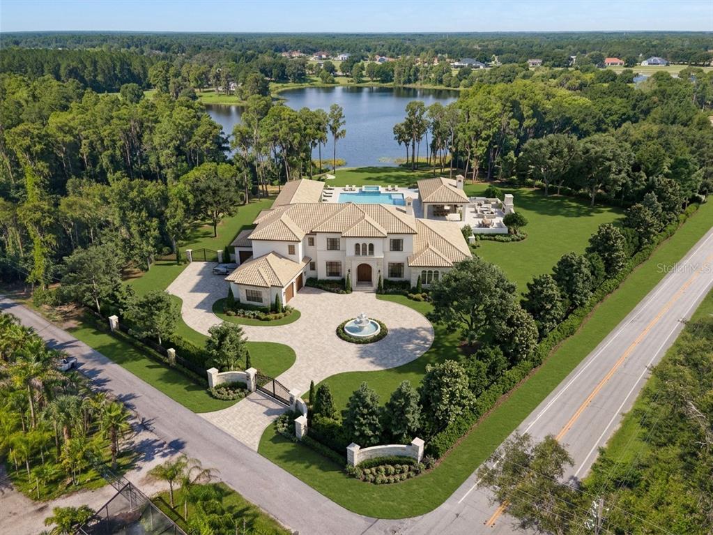 An aerial view of a lake surrounded by dense forest at sunset — 18150 BURRELL ROAD, ODESSA, FL