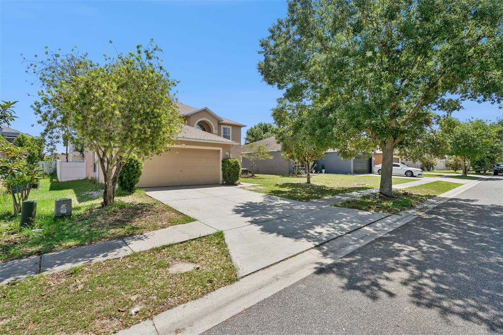 A two-story house with a beige exterior, a two-car garage, and a concrete driveway — 416 BARLYN AVENUE, HAINES CITY, FL