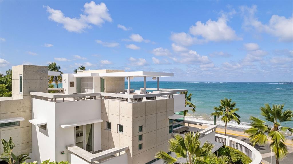 A modern multi-level concrete house with a rooftop terrace overlooking the ocean and palm trees — 2220 PARK BOULEVARD, SAN JUAN, PR