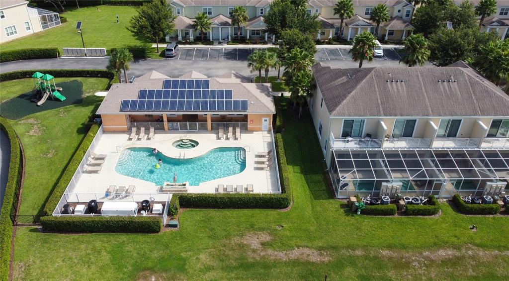 An aerial view shows a community swimming pool, a playground, and adjacent residential townhomes — 17417 PLACIDITY AVENUE, CLERMONT, FL
