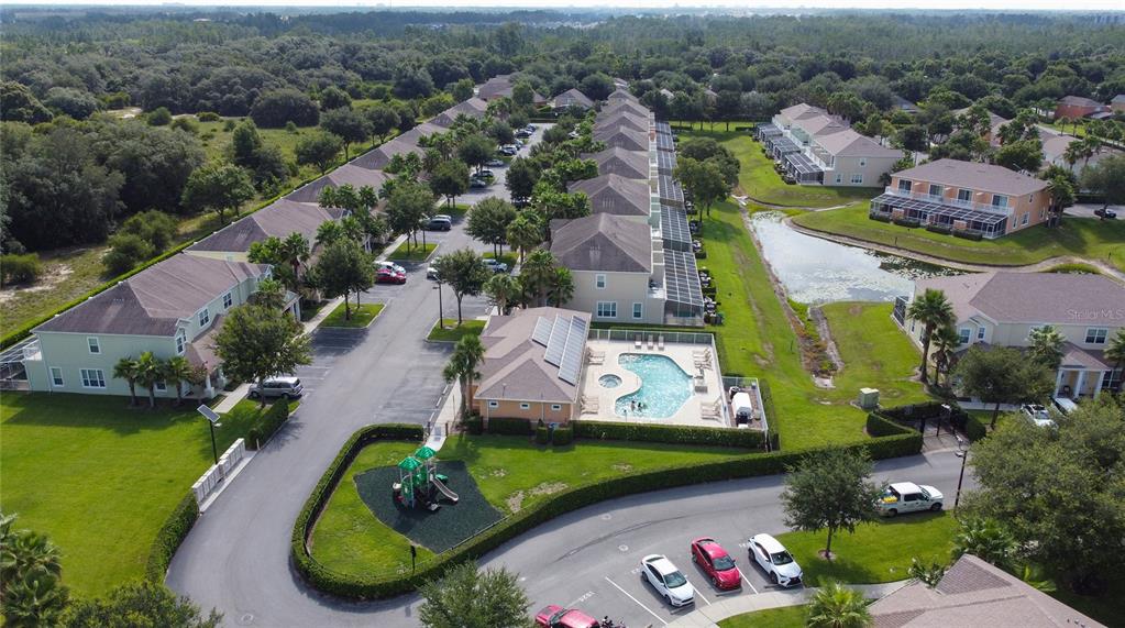 An aerial view shows a residential complex with a swimming pool, playground, and parking lot — 17417 PLACIDITY AVENUE, CLERMONT, FL