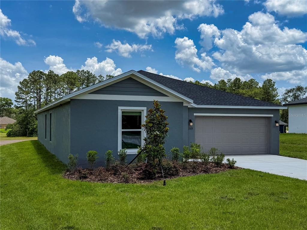 A gray single-story house with a two-car garage and a landscaped front yard — 13079 SW 86TH COURT, OCALA, FL