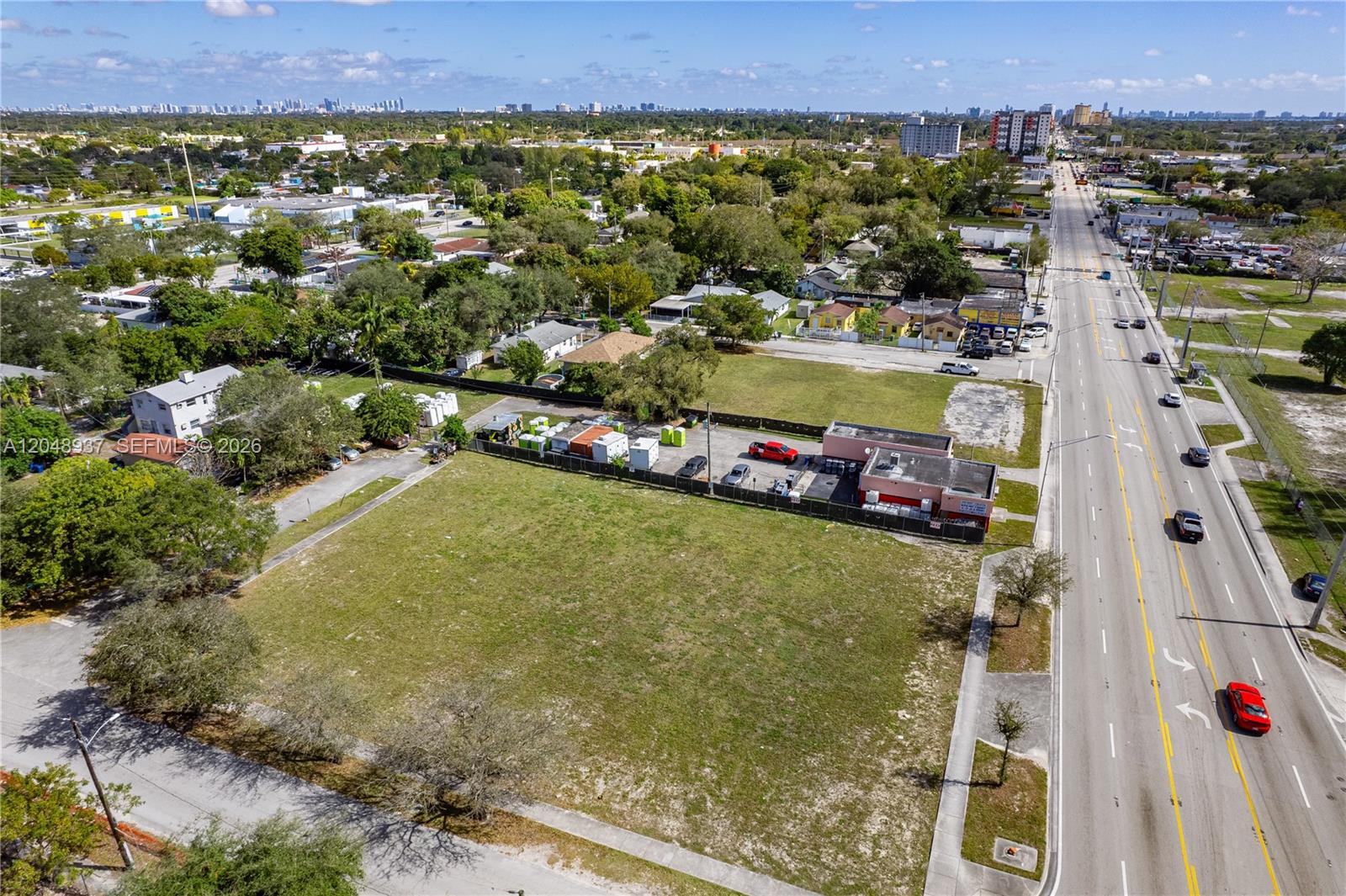 An aerial view shows a large vacant lot next to a fenced commercial property — 1113 NW 79th St, Miami FL 33150, MIAMI, FL