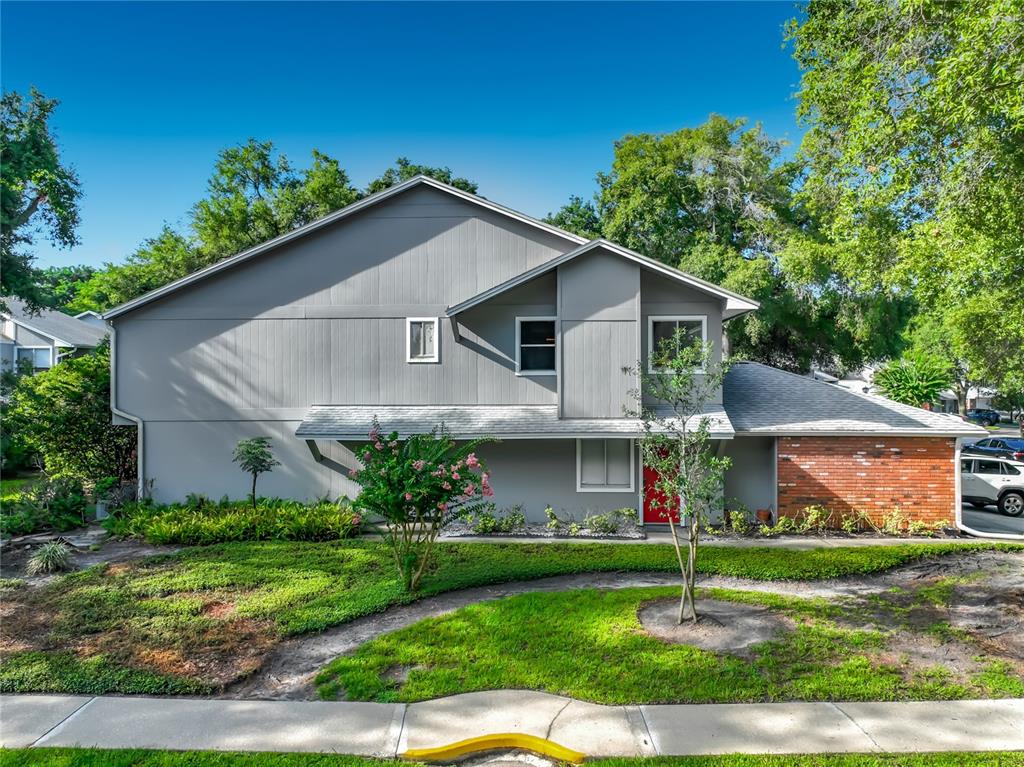 A two-story house with gray vertical siding, a red front door, and a brick accent wall — 645 LAUREL OAK LANE UNIT 201, ALTAMONTE SPRINGS, FL