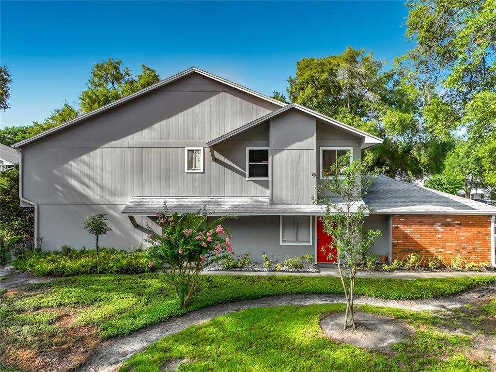 A two-story house with gray vertical siding, a red front door, and brick accents — 645 LAUREL OAK LANE UNIT 201, ALTAMONTE SPRINGS, FL