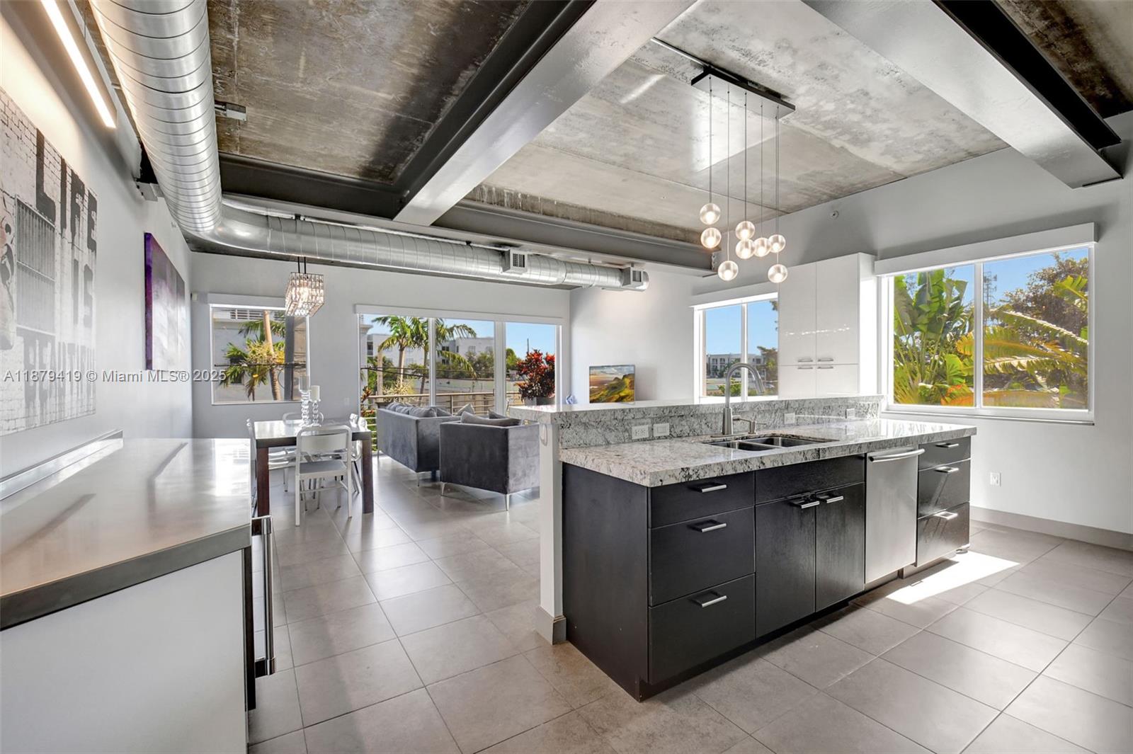 A modern kitchen and living area feature concrete ceilings, exposed ductwork, and granite countertops — 110 SE 2nd ST # 203, Delray Beach FL 33444, DELRAY BEACH, FL