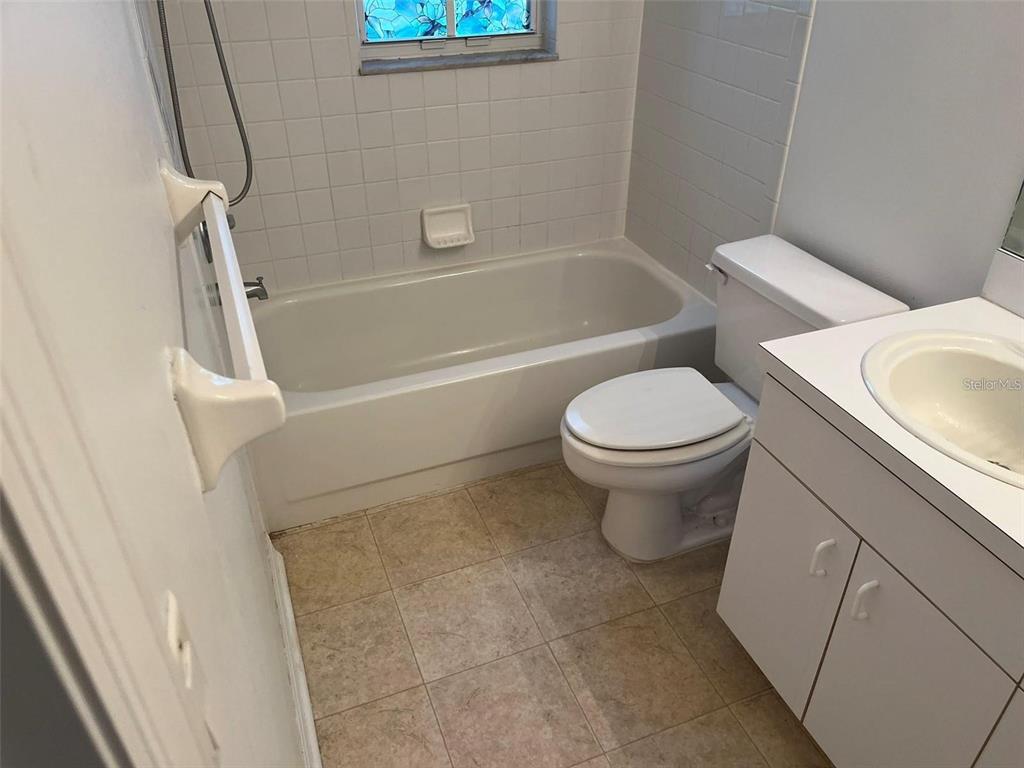 A bathroom featuring a white bathtub, a toilet, and a vanity with a sink — 5316 COTTONWOOD TREE CIRCLE, VALRICO, FL
