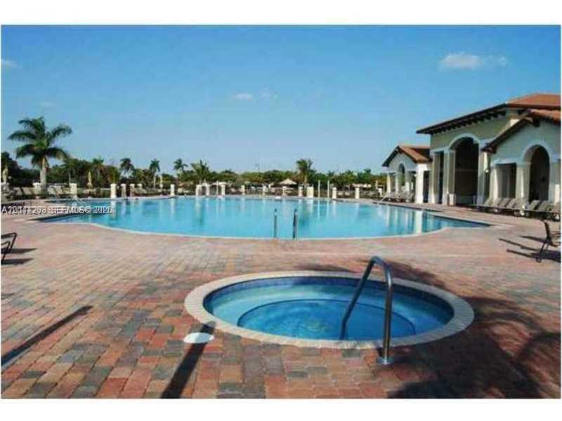 A circular hot tub sits on a brick patio in front of a large swimming pool — 9209 SW 227th St # 4, Cutler Bay FL 33190, CUTLER BAY, FL