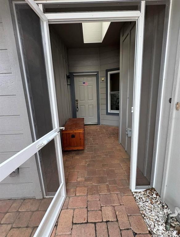A paved entryway leads to a front door with a wooden chest and skylight — 39650 US HIGHWAY 19 N UNIT 441, TARPON SPRINGS, FL