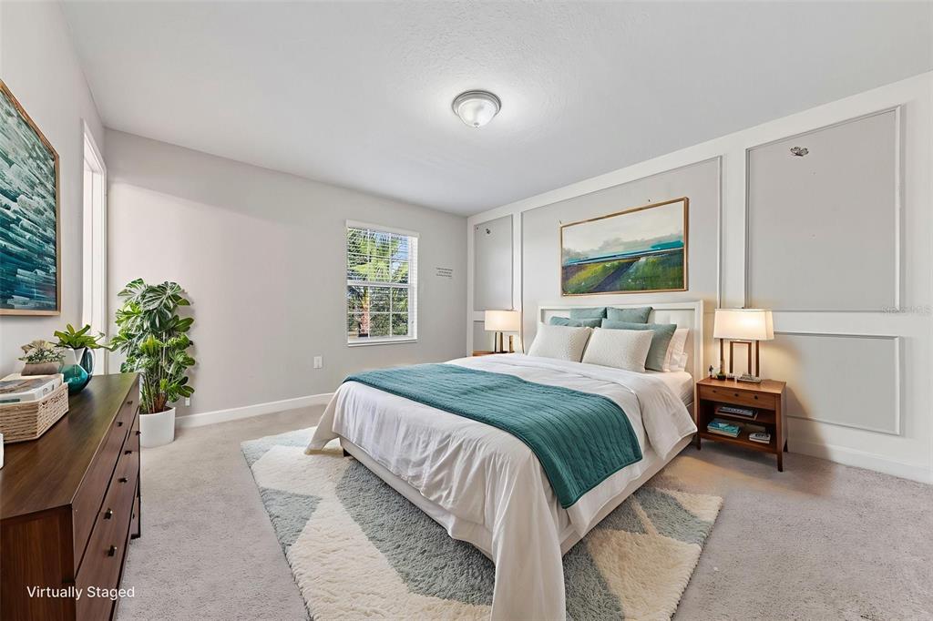 A bedroom features a bed with a teal throw, wall molding, and a patterned rug — 11626 EPIC AVENUE, ORLANDO, FL