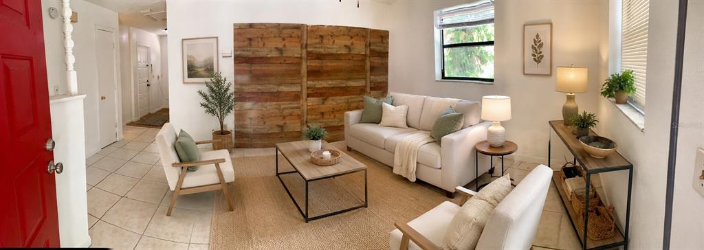 A living room features a wood-paneled accent wall, a light-colored sofa, and tile flooring — 1735 TIMOCUAN WAY UNIT B, LONGWOOD, FL