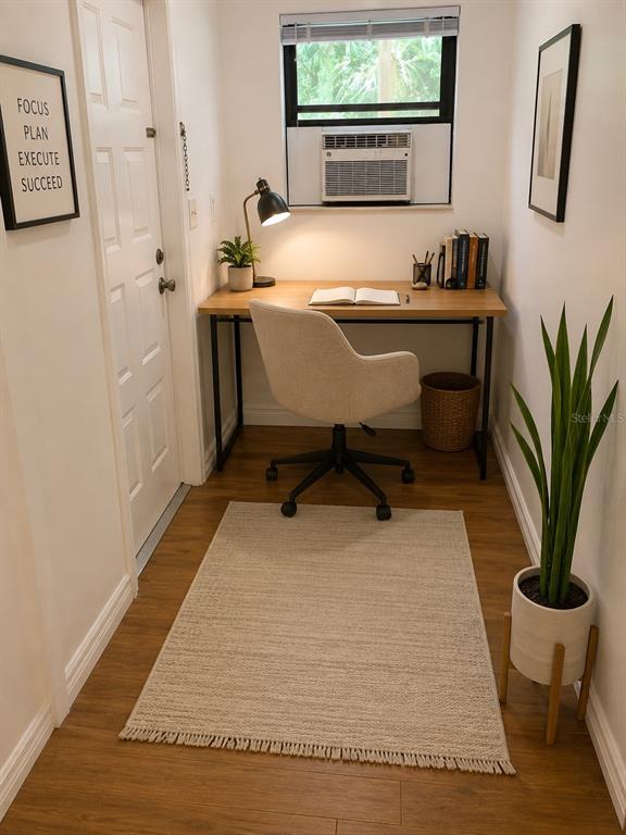 A small home office features a wooden desk, an upholstered chair, and a window air conditioner — 1735 TIMOCUAN WAY UNIT B, LONGWOOD, FL
