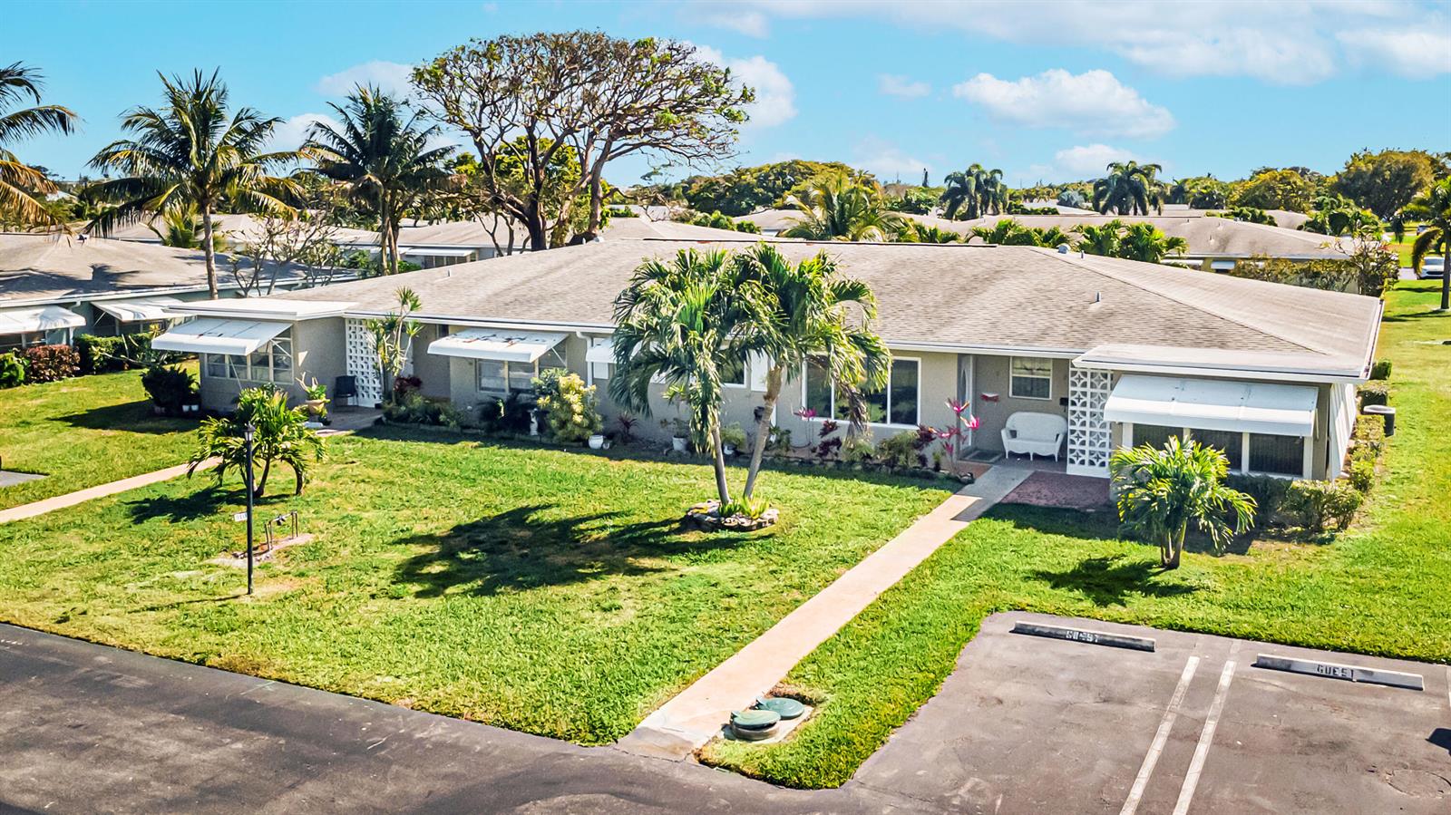 An aerial view shows a single-story residential building with a lawn and parking spaces — 310 Main Boulevard # C, Boynton Beach FL 33435, BOYNTON BEACH, FL