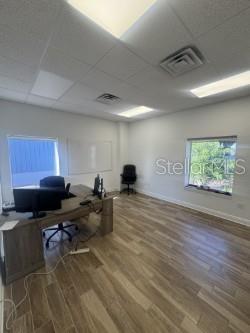 An office with wood-look flooring, a desk with computer equipment, and a whiteboard on the wall — 4908 DENVER STREET, TAMPA, FL
