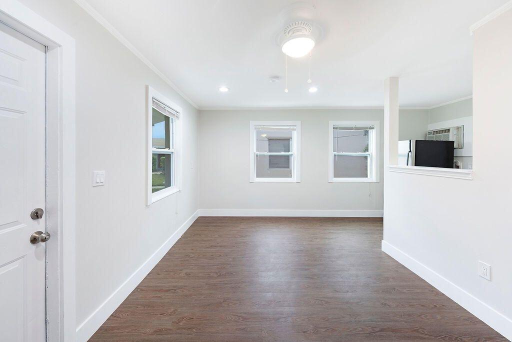 An empty room with white walls, dark wood-look flooring, and two windows — 1883 Smith Drive # 2, FL 33408, FL