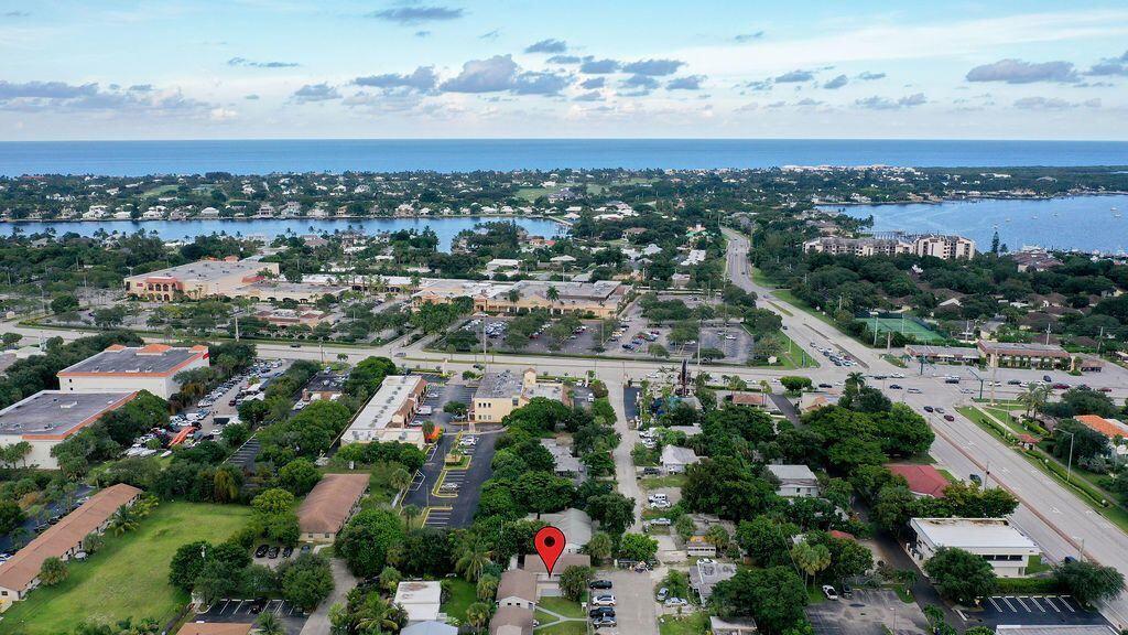 An aerial view shows a commercial building with a red location pin in a coastal town — 1883 Smith Drive # 2, FL 33408, FL