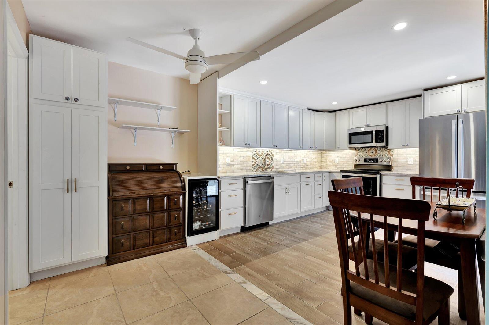 A kitchen with white cabinets, stainless steel appliances, a wine cooler, and a wooden roll-top desk — 3016 30th Court, Jupiter FL 33477, JUPITER, FL