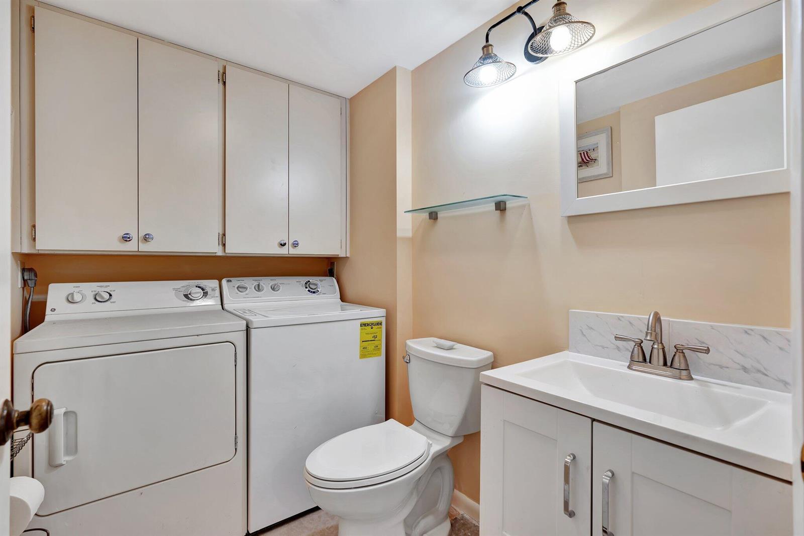 A laundry room featuring a washer, dryer, toilet, and a white vanity with a sink — 3016 30th Court, Jupiter FL 33477, JUPITER, FL