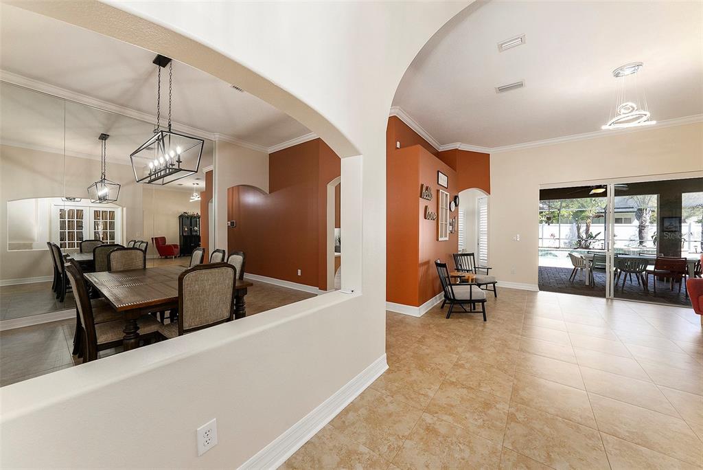A dining room with a mirror wall and a living area with tile floors — 19328 AUTUMN WOODS AVENUE, TAMPA, FL