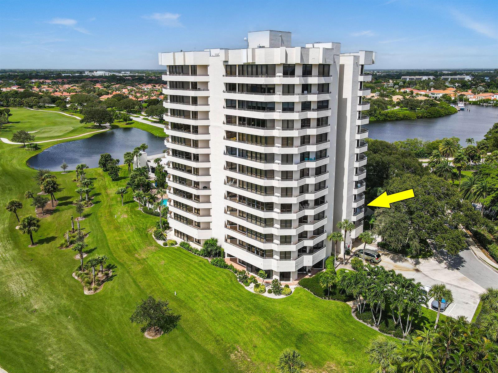 An aerial view of a tall white residential building surrounded by a golf course — 3322 Casseekey Island Road # 302, Jupiter FL 33477, JUPITER, FL