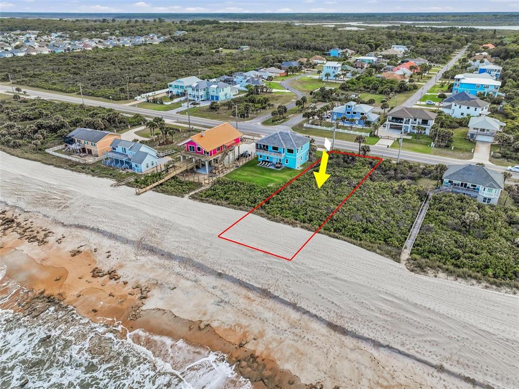 An aerial view shows a vacant, rectangular oceanfront lot outlined in red next to houses — 7103 N OCEAN SHORE BOULEVARD, PALM COAST, FL