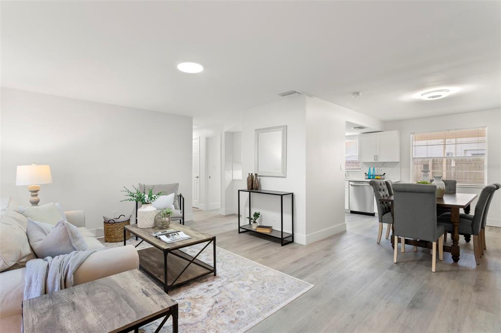 An open-concept living and dining area features light wood flooring and neutral wall colors — 1524 ARIZONA AVENUE NE, ST PETERSBURG, FL